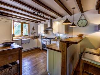 This charming kitchen boasts rustic wooden beams and a farmhouse sink, creating a warm and inviting atmosphere.