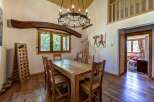 Experience rustic charm in this dining room featuring a solid wood table and chairs, perfect for family gatherings.