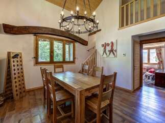 Experience rustic charm in this dining room featuring a solid wood table and chairs, perfect for family gatherings.