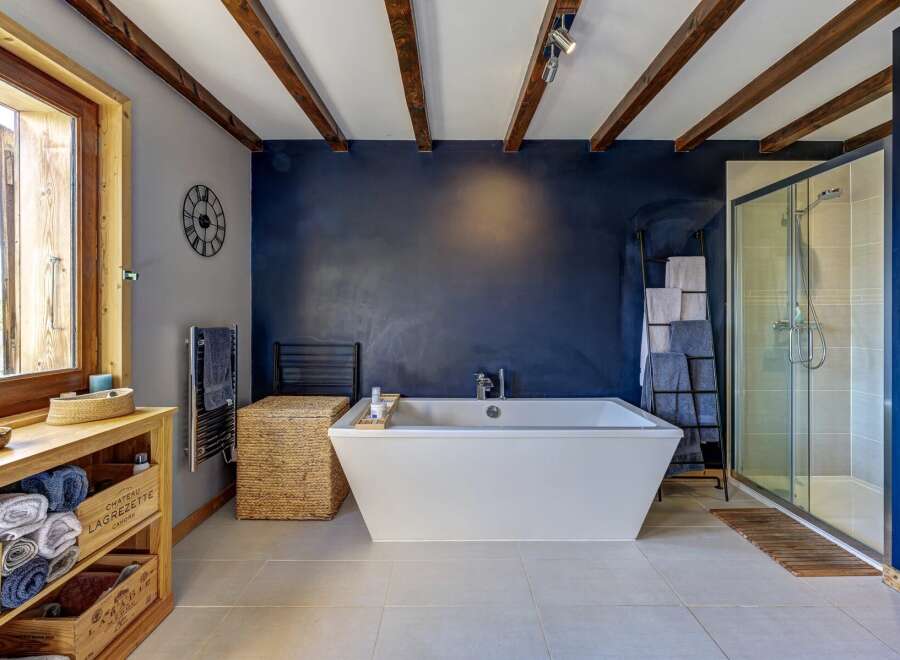 Experience rustic charm and modern luxury in this stunning bathroom, featuring a deep soaking tub and a spacious glass-enclosed shower.