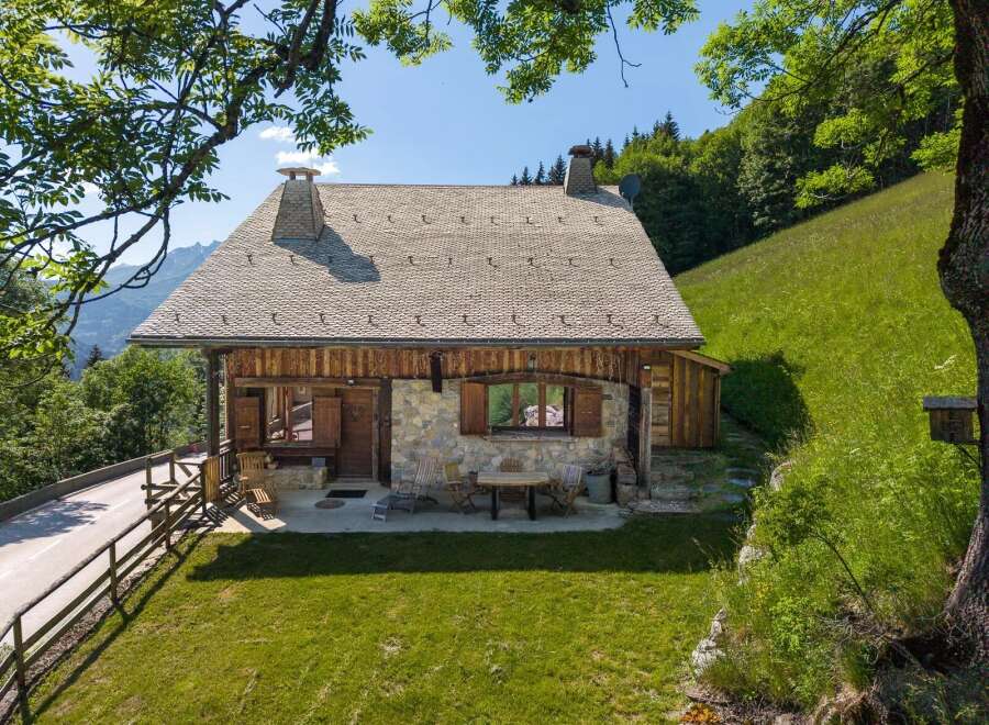 Experience serene mountain living in this charming stone and wood chalet, nestled amidst lush green hills and offering breathtaking views.