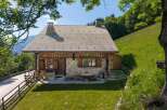 Experience serene mountain living in this charming stone and wood chalet, nestled amidst lush green hills and offering breathtaking views.