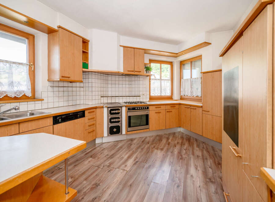This charming kitchen features warm wooden cabinetry and a tiled backsplash, creating a cozy and inviting atmosphere.