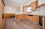 Discover this charming kitchen featuring warm wooden cabinetry and a cozy dining nook.