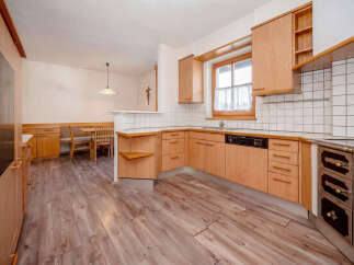 Discover this charming kitchen featuring warm wooden cabinetry and a cozy dining nook.