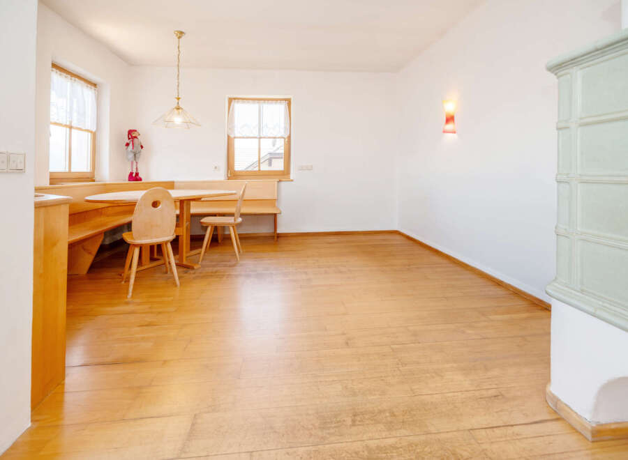 This charming dining area features a cozy built-in wooden bench seating and a round wooden table, perfect for intimate meals.