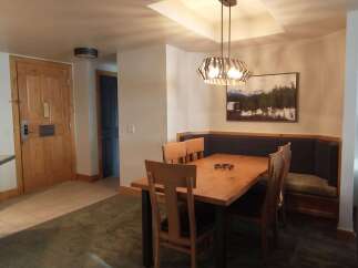 This inviting dining area features a warm wooden table surrounded by comfortable chairs and a built-in banquette, perfect for family meals.