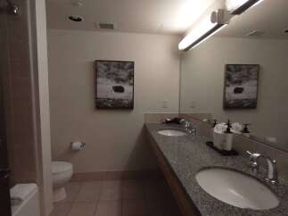 This spacious bathroom features a double vanity with granite countertops and modern fixtures, perfect for busy mornings.