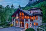Experience luxury mountain living in this stunning stone and timber lodge nestled amidst a serene forest.