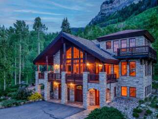 Experience luxury mountain living in this stunning stone and timber lodge nestled amidst a serene forest.