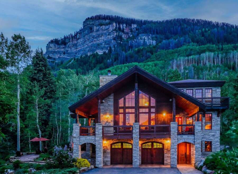 Experience luxury mountain living in this stunning stone and timber home, nestled against a majestic mountain backdrop.