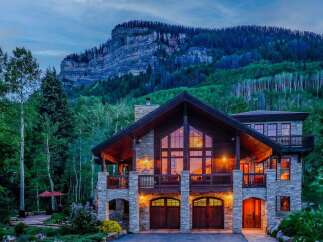 Experience luxury mountain living in this stunning stone and timber home, nestled against a majestic mountain backdrop.