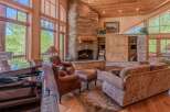 Experience luxury living in this stunning great room, featuring a grand stone fireplace and soaring windows that flood the space with natural light.