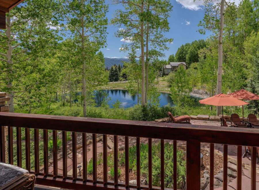 Enjoy serene mountain living with this stunning property featuring a private pond and lush greenery.