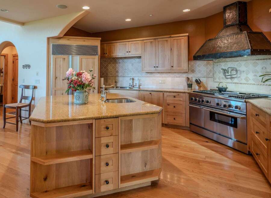 This spacious kitchen features a large island with a granite countertop, perfect for meal preparation and casual dining.