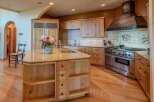 This spacious kitchen features a large island with a granite countertop, perfect for meal preparation and casual dining.