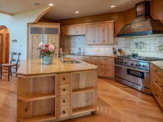 This spacious kitchen features a large island with a granite countertop, perfect for meal preparation and casual dining.