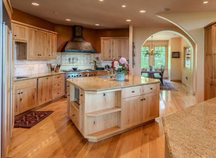 Experience luxury in this stunning kitchen featuring custom light wood cabinetry and granite countertops.