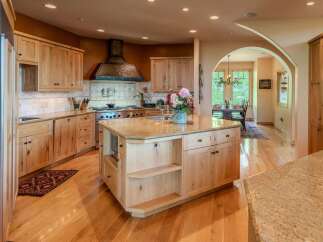 Experience luxury in this stunning kitchen featuring custom light wood cabinetry and granite countertops.