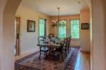 Experience elegant dining in this beautifully appointed dining room, featuring a large wooden table set for a feast.