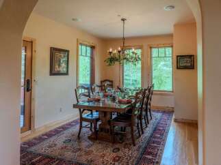 Experience elegant dining in this beautifully appointed dining room, featuring a large wooden table set for a feast.