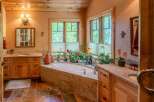 Indulge in relaxation in this luxurious bathroom featuring a spacious soaking tub surrounded by lush greenery and natural light.