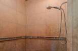 Experience a spa-like retreat in this beautifully tiled shower featuring a modern handheld showerhead.