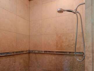 Experience a spa-like retreat in this beautifully tiled shower featuring a modern handheld showerhead.