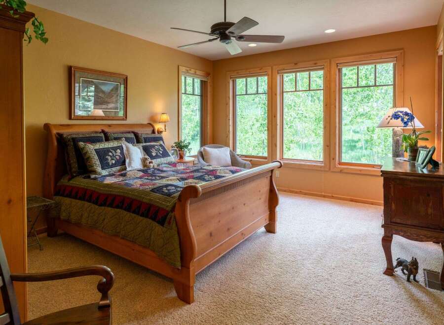 Experience serene living in this charming bedroom featuring a cozy sleigh bed adorned with a beautiful quilt.