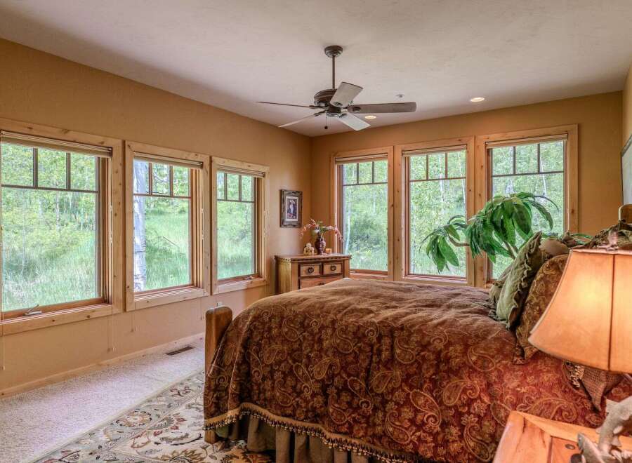 Experience serene living in this charming bedroom, featuring a cozy bed adorned with a rich paisley comforter and a decorative bed skirt.