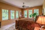 Experience serene living in this charming bedroom, featuring a cozy bed adorned with a rich paisley comforter and a decorative bed skirt.