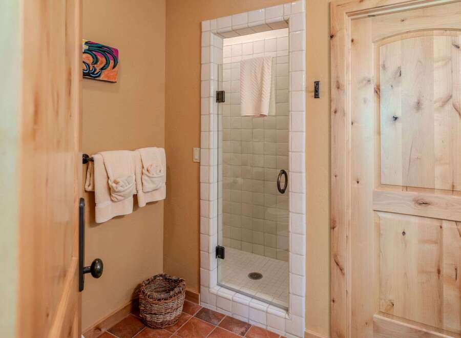 Step into a spa-like bathroom featuring a charming glass-enclosed shower with white tiled walls and a convenient towel rack.