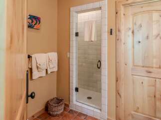 Step into a spa-like bathroom featuring a charming glass-enclosed shower with white tiled walls and a convenient towel rack.