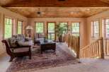 Experience rustic charm in this inviting living space, featuring a cozy seating area with plush cushions and a traditional patterned rug.