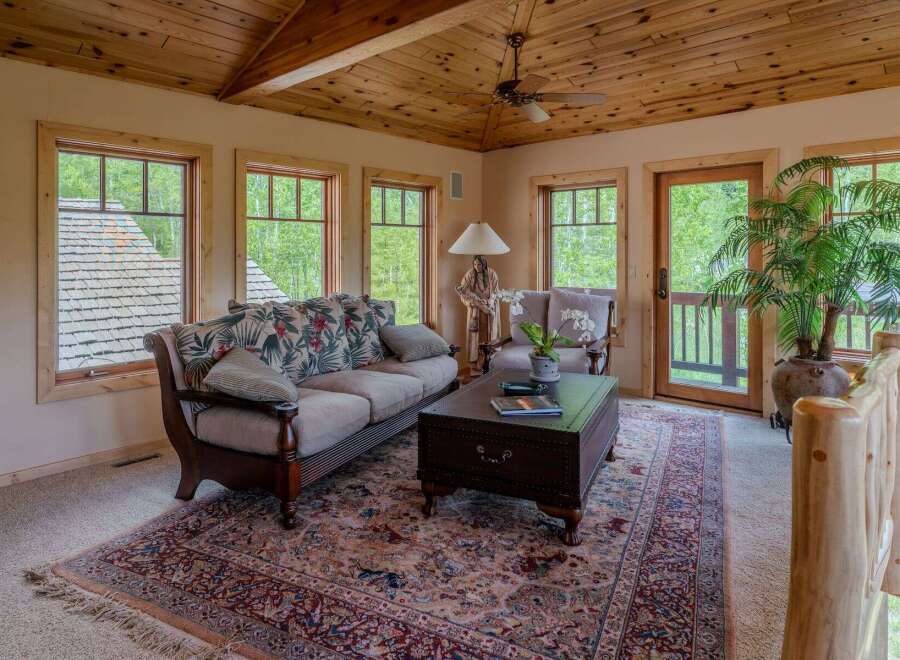 Experience rustic charm in this inviting living room, featuring a floral-patterned sofa and a traditional rug.