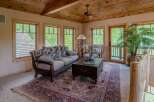 Experience rustic charm in this inviting living room, featuring a floral-patterned sofa and a traditional rug.