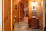This charming bathroom features a rustic wooden vanity with a vessel sink, complemented by warm orange walls and natural wood accents.