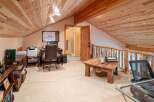 Discover this charming attic office space, featuring a rustic wooden ceiling and a cozy work area.