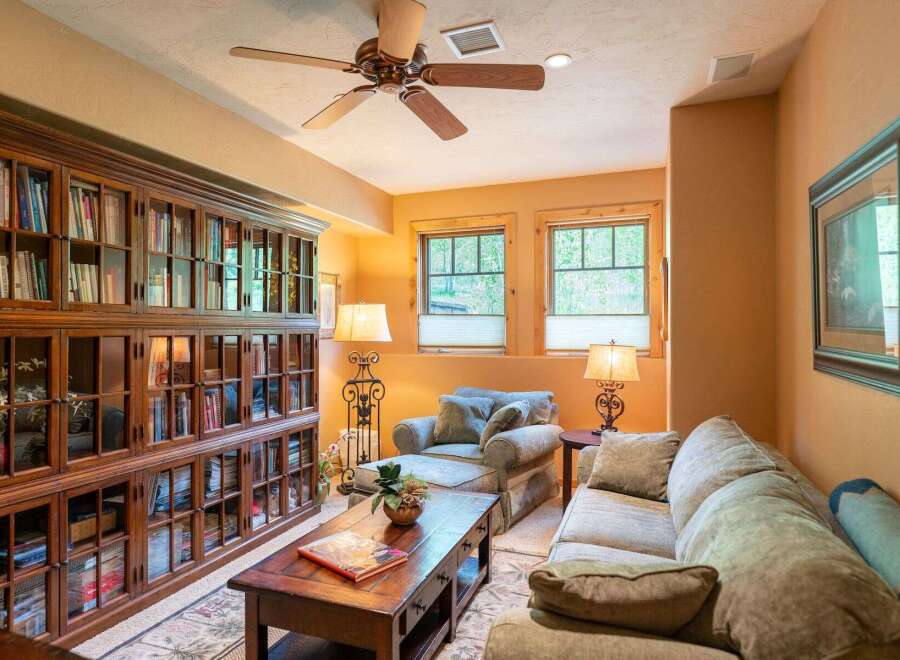 This cozy living room features a large, built-in wooden bookshelf filled with books, creating a warm and inviting atmosphere.