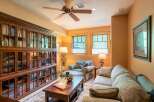 This cozy living room features a large, built-in wooden bookshelf filled with books, creating a warm and inviting atmosphere.