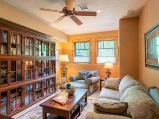 This cozy living room features a large, built-in wooden bookshelf filled with books, creating a warm and inviting atmosphere.