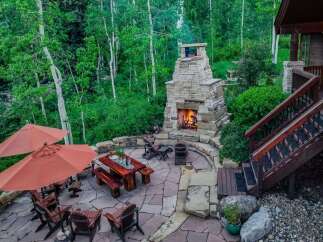 Experience outdoor living at its finest with this stunning patio featuring a grand stone fireplace, perfect for cozy evenings.