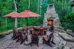 Experience the ultimate outdoor living with this stunning patio featuring a grand stone fireplace and comfortable seating.