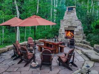 Experience the ultimate outdoor living with this stunning patio featuring a grand stone fireplace and comfortable seating.