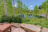 Escape to this serene oasis featuring a tranquil pond surrounded by lush greenery and mature aspen trees.