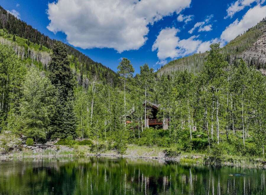 Nestled amidst a serene forest and overlooking a tranquil lake, this stunning property offers a unique blend of natural beauty and rustic charm.