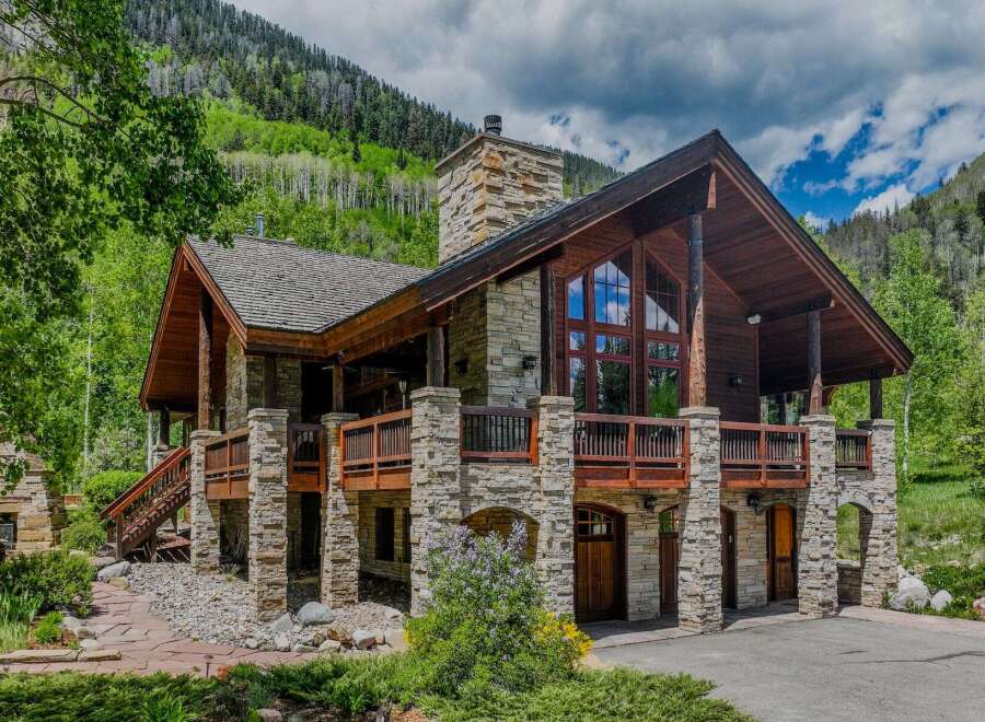 Experience luxury mountain living in this stunning stone and timber home nestled amidst breathtaking natural beauty.
