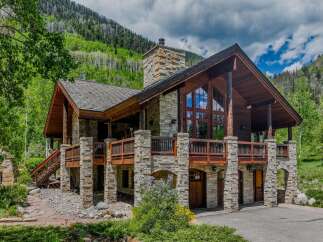 Experience luxury mountain living in this stunning stone and timber home nestled amidst breathtaking natural beauty.