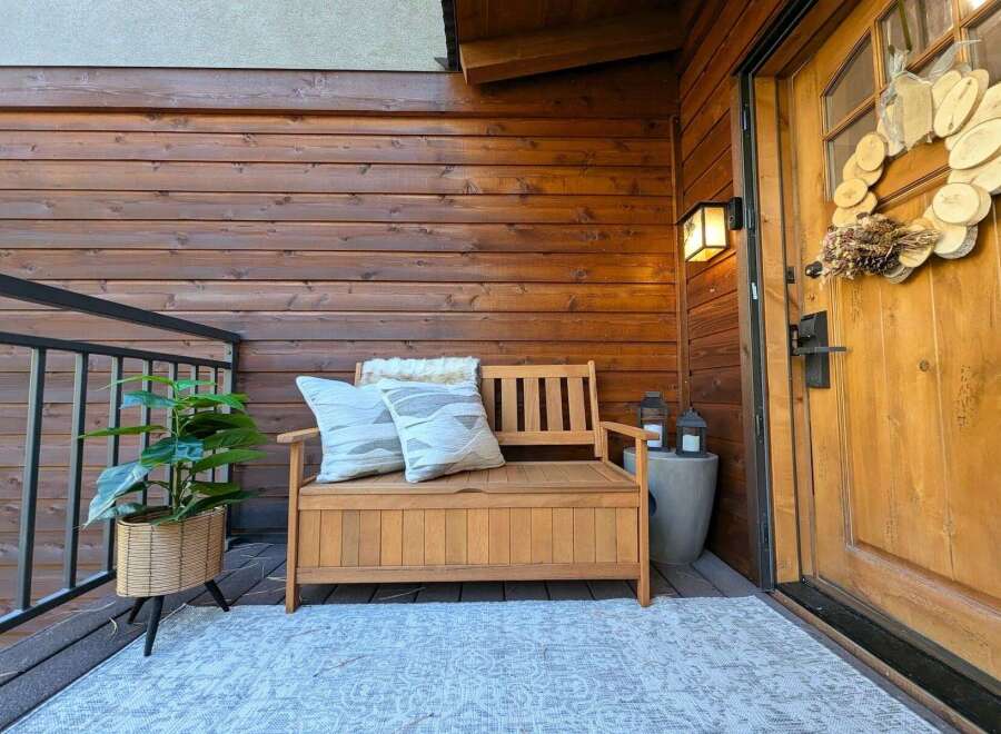 Enhance your home's curb appeal with this inviting porch setup, featuring a charming wooden bench with storage, perfect for outdoor seating and organization.