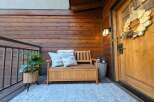 Enhance your home's curb appeal with this inviting porch setup, featuring a charming wooden bench with storage, perfect for outdoor seating and organization.